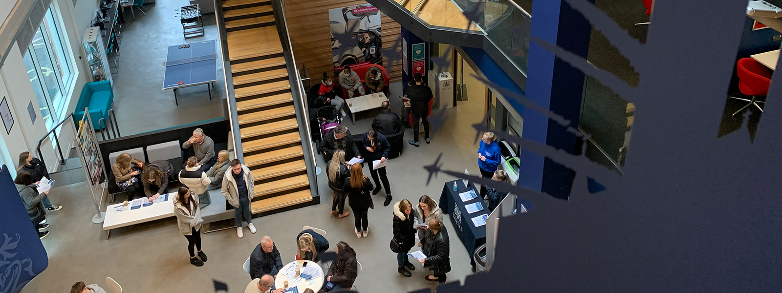 Students, staff, and parents chatting in the business school atrium